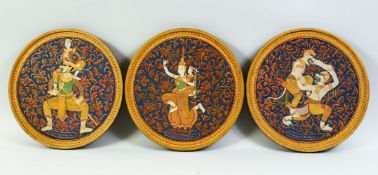 THREE THAI CIRCULAR PAINTINGS ON WOOD, painted with buddhist deities and figures, embellished with
