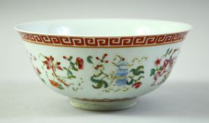 A CHINESE FAMILLE ROSE PORCELAIN BOWL, decorated with symbolic emblems and with greek key band to