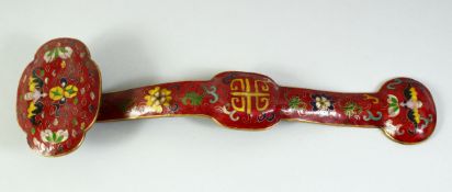 A CHINESE CLOISONNE RUYI SCEPTRE, red ground, decorated with bats and flowers. 1ft 4ins long.