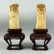 A PAIR OF JAPANESE MEIJI PERIOD CARVED IVORY TUSK VASES, circa 1890, the tusks mounted to hardwood