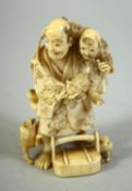 A JAPANESE CARVED IVORY NETSUKE, of a father and son, the father holding a turtle with dogs at his