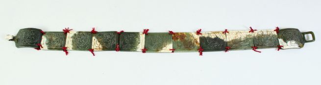 A CHINESE OR TIBETAN SECTIONAL CARVED JADE BELT, the surface of each section carved with a figure,