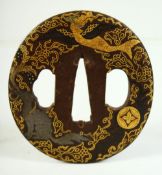 A SMALL JAPANESE SHAKUDO STEEL TSUBA, decorated with a dragon, phoenix and a horse, 6.5cm x 6cm.