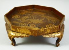 A JAPANESE GOLD LACQUER OCTAGONAL STAND, finely decorated with prunus trees, bamboo and bamboo on