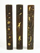 A SET OF THREE JAPANESE SHAKUDO KOZUKA KNIFE HANDLES, one depicting fishing boats at sea, another of