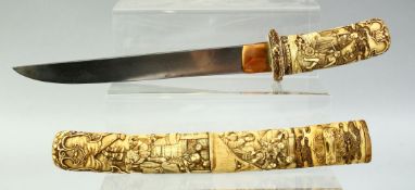 A JAPANESE CARVED IVORY TANTO DAGGER, the scabbard and handle finely carved with village scenes