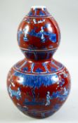 A CHINESE IRON RED AND BLUE DOUBLE GOURD PORCELAIN VASE, decorated with various figures in an