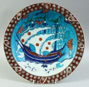 A TURKISH OTTOMAN IZNIK PLATE, decorated with a boat and fish, 31cm diameter.