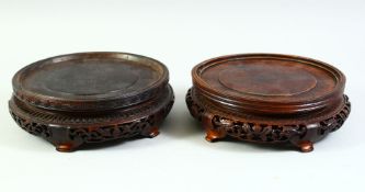 TWO MATCHED CHINESE CARVED AND PIERCED CIRCULAR HARDWOOD STANDS, both housing a base of approx.