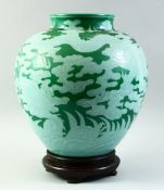 A VERY LARGE UNUSUAL CHINESE GREEN GROUND DRAGON VASE and hardwood stand, decorated with a dragon