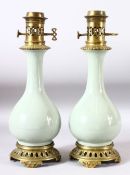 A PAIR OF CELADON PORCELAIN VASES CONVERTED TO LAMPS with brass mounts, 40cm high.