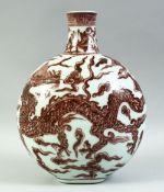 A CHINESE UNDER GLAZE RED PORCELAIN MOON FLASK, painted with a dragon amongst stylised flames and