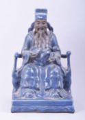 A LARGE CHINESE POWDER BLUE GLAZE POTTERY SEATED FIGURE of a god, the figure seated upon a throne
