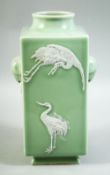 A CHINESE CELADON GLAZE SQUARE FORM VASE, decorated with carved cranes and two moulded ring handles,