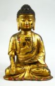 A GILT BRONZE SHAKYAMUNI BUDDHA, with four character mark to reverse, 27cm high.