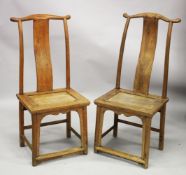 A PAIR OF CHINESE ELM YOKE BACK CHAIRS, possibly 18th century or earlier, with plain curving back