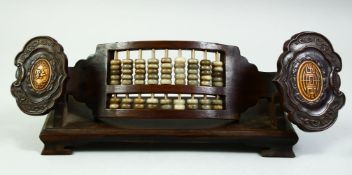 A CHINESE WOODEN ABACUS IN RUYI SCEPTER, with wooden stand, 32cm long.