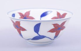 A CHINESE MING STYLE PORCELAIN BOWL, painted with large flower heads in red, six character mark to