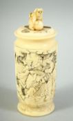 A SMALL JAPANESE CARVED IVORY CYLINDRICAL POT AND COVER, carved with various figures in an outdoor