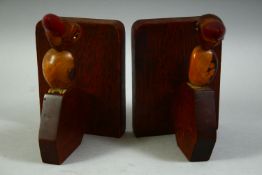 A PAIR OF DUNHILL HENRY HOWELL STYLE BIRD FORM BOOK STANDS WITH BAKELITE BEAKS.