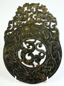 A CHINESE CARVED AND PIERCED HARDSTONE DISK, carved with mythological beasts, 24.5cm x 17.5cm.