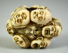 A JAPANESE CARVED IVORY NETSUKE, carved as a roundel of noh masks, 5.5cm.