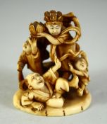 A JAPANESE CARVED IVORY NETSUKE, depicting a playful scene with a male and female figure with