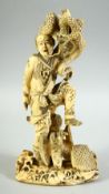 A JAPANESE CARVED IVORY OKIMONO, of a male figure holding a snake aloft, the man with an eagle at