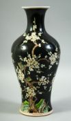 A CHINESE FAMILLE NOIR PORCELAIN VASE, decorated with prunus blossom and birds, 28cm high.