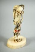 AN UNUSUAL JAPANESE CARVED IVORY OKIMONO, depicting a skeleton and two monkeys, 11.5cm high.