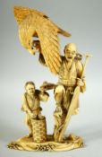 A JAPANESE CARVED IVORY OKIMONO GROUP, depicting a fisherman holding a large eagle aloft, his boy