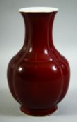 A CHINESE OX BLOOD GLAZE PORCELAIN VASE, the base with six character mark, 22cm high.