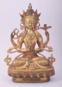 A TIBETAN GILT BRONZE MODEL OF A SEATED DEITY, 28cm high.