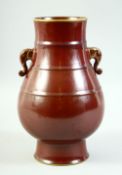A CHINESE OX BLOOD TWIN HANDLE PORCELAIN VASE, the handles in the form of elephants with painted
