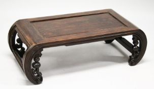 A CHINESE ROSEWOOD LOW TABLE WITH PANELLED TOP, supported on curving ends with pierced and carved b