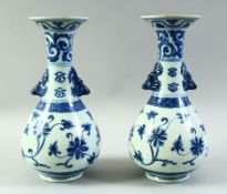 A PAIR OF CHINESE BLUE AND WHITE PORCELAIN VASES, with formed handles and floral decoration, 27.