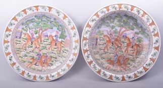 TWO LARGE CHINESE EXPORT PORCELAIN CHARGERS, painted with European scenes depicting figures on