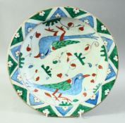 A TURKISH OTTOMAN IZNIK PLATE, painted with birds, 30.5cm diameter.