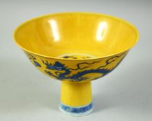 A CHINESE YELLOW GROUND PORCELAIN STEM CUP, the bowl decorated with dragons and the flaming pearl of