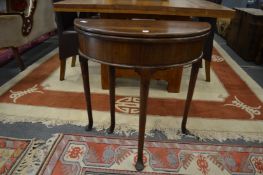 A George III small mahogany demi-lune foldover tea table (alterations).