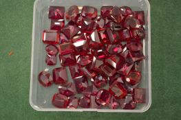 A box of ruby coloured stones.