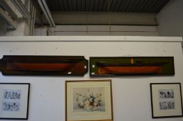 Two carved wood and painted cutaway models of ship's hulls.