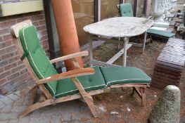 A pair of teak steamer style reclining armchairs.