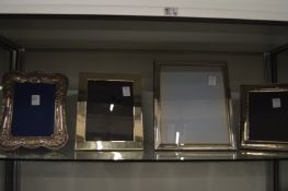 Four large silver plated photograph frames.