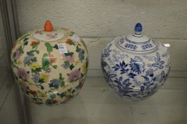 A large Chinese Famille Rose style jar and cover and a similar blue and white jar and cover.