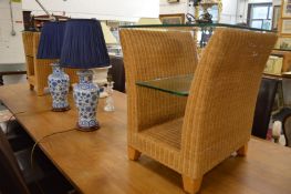 A pair of wicker and glass lamp tables.