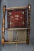 A partly woven Persian rug on a small loom.