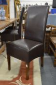 A set of six brown leather upholstered highback modern dining chairs.