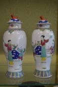 A pair of Famille Rose baluster shaped vases and covers.