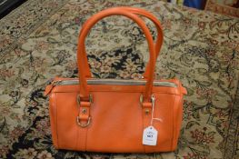 A Gucci orange leather handbag.